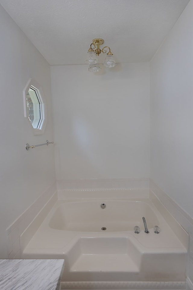 bathroom with a bathing tub and a textured ceiling