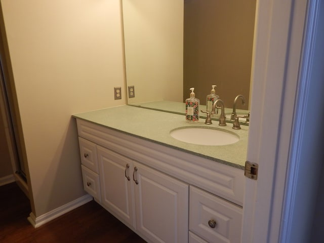 bathroom with baseboards, wood finished floors, and vanity