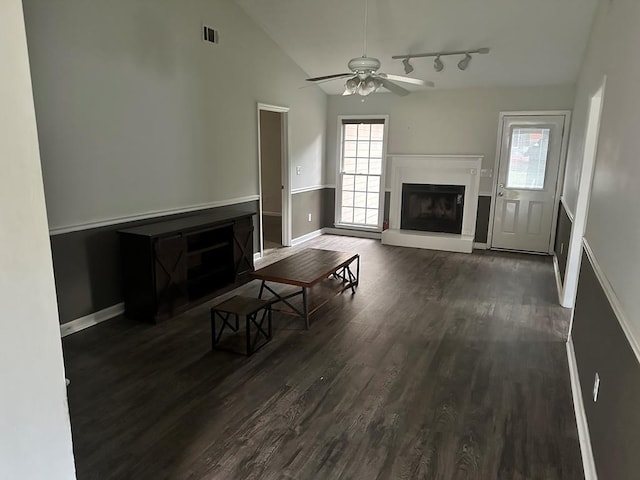 unfurnished living room featuring ceiling fan, lofted ceiling, and dark wood-type flooring