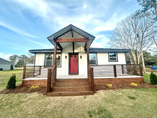 view of front of house with covered porch, board and batten siding, and a front yard