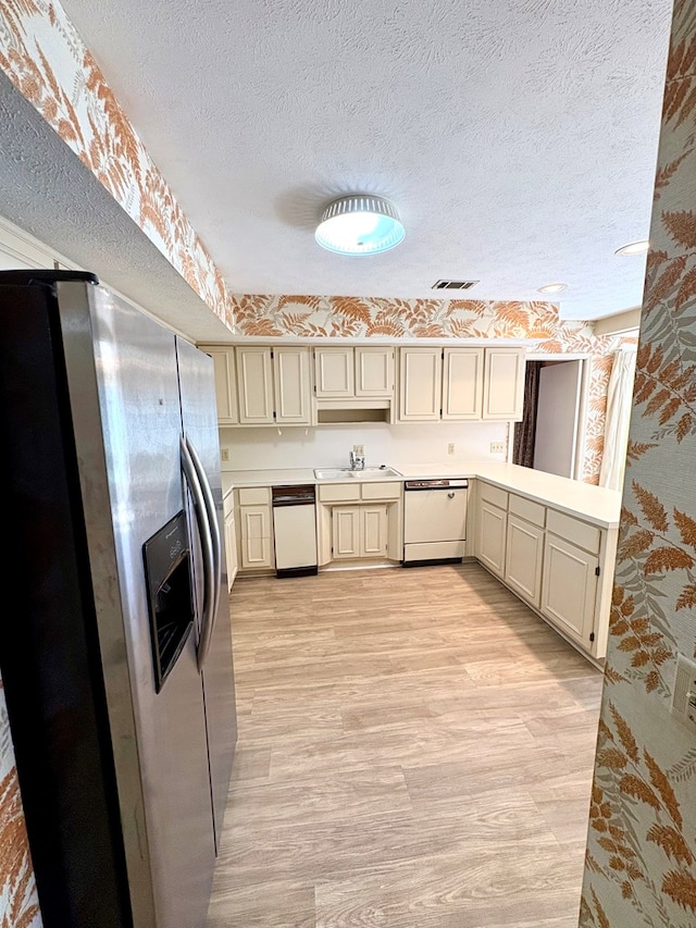 5302 Pine Needle Dr, Columbus, GA 31907 - kitchen featuring stainless steel refrigerator with ice dispenser, white dishwasher, light countertops, a textured ceiling, and light wood-style floors