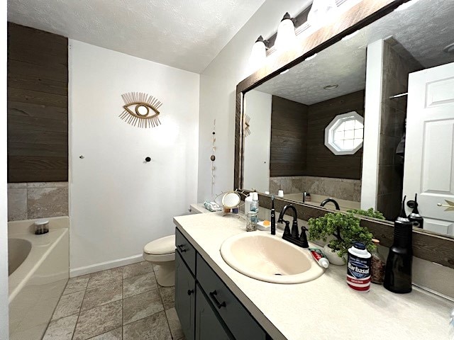 bathroom with vanity, a textured ceiling, a tub to relax in, and toilet