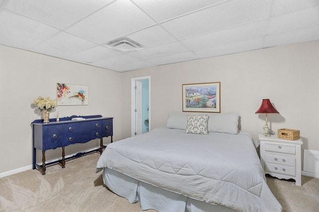 bedroom featuring light colored carpet and a drop ceiling