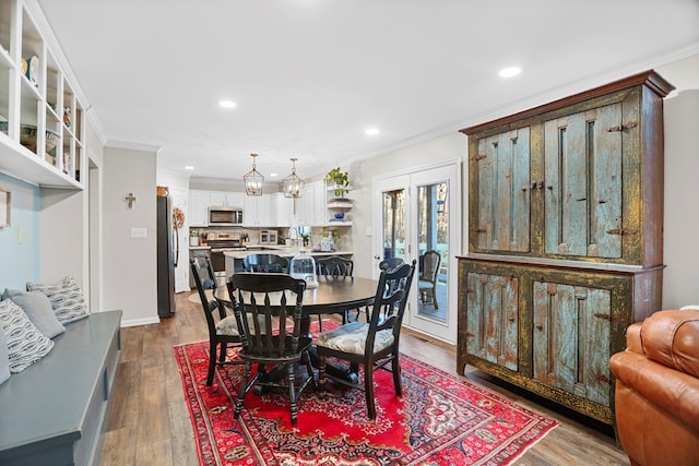 dining space with a chandelier, hardwood / wood-style flooring, and crown molding