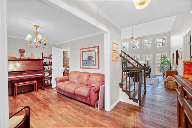 living room with hardwood / wood-style flooring, ceiling fan with notable chandelier, and crown molding