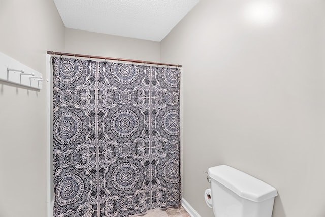 bathroom featuring a textured ceiling and toilet