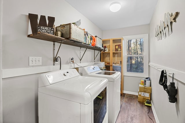 laundry room with washing machine and dryer and hardwood / wood-style flooring