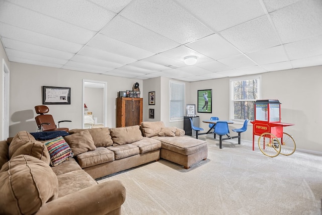 carpeted living room with a drop ceiling