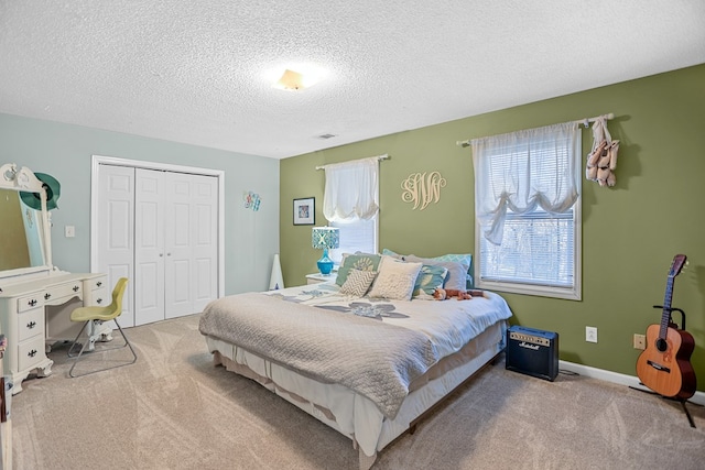 carpeted bedroom with a textured ceiling and a closet