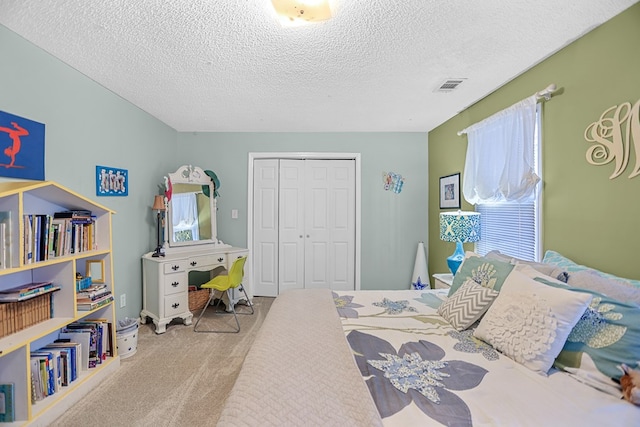 carpeted bedroom featuring a closet and a textured ceiling