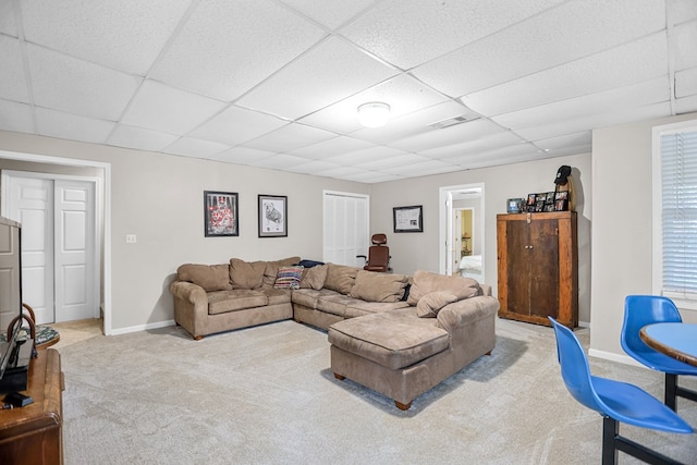 carpeted living room featuring a paneled ceiling