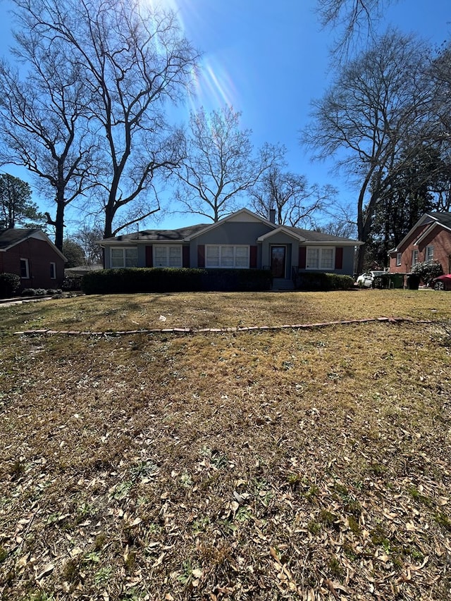 view of front of home featuring a chimney and a front lawn