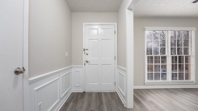 6847 Fawndale Dr, Columbus, GA 31904 - foyer featuring wood finished floors, a wainscoted wall, a decorative wall, and a textured ceiling