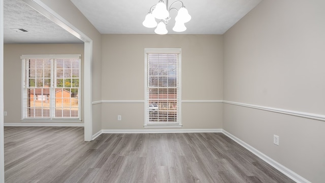 6847 Fawndale Dr, Columbus, GA 31904 - spare room with a chandelier, wood finished floors, and healthy amount of natural light