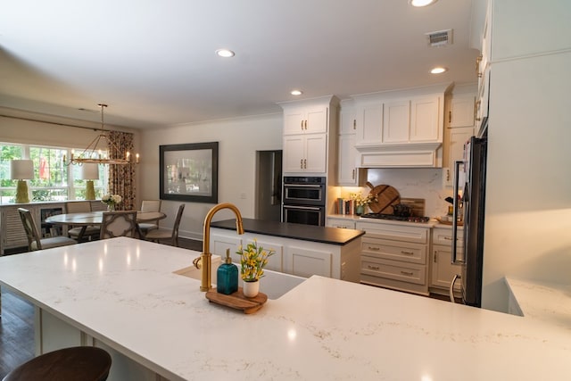 719 Harris Rd, Cataula, GA 31804 - kitchen featuring stainless steel gas cooktop, freestanding refrigerator, a chandelier, white cabinetry, and recessed lighting