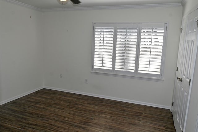 spare room featuring ornamental molding, dark wood-style flooring, and baseboards