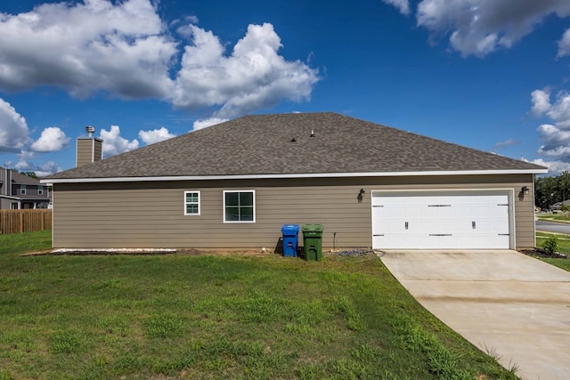 back of house featuring a yard and a garage