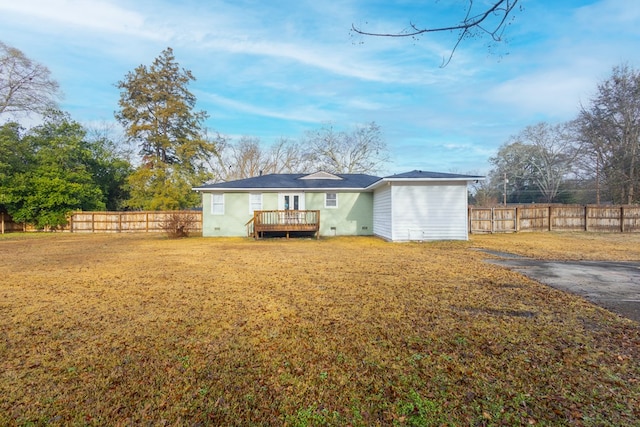 rear view of property with a yard and a deck