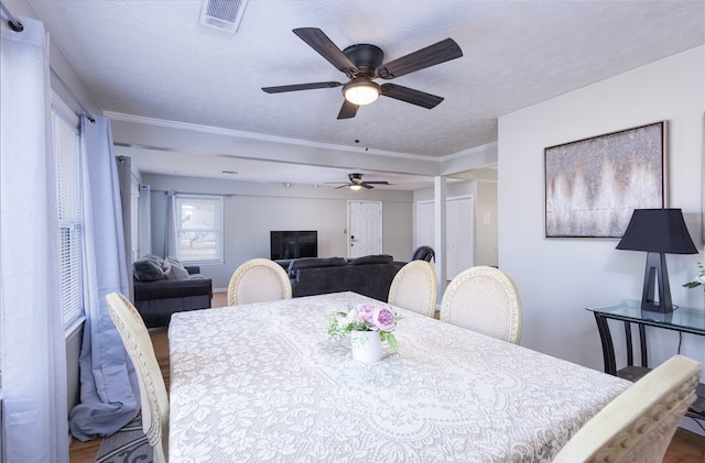 dining space featuring hardwood / wood-style floors, crown molding, and a textured ceiling