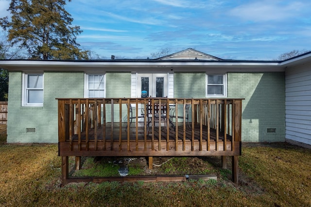 rear view of house with a wooden deck and a yard