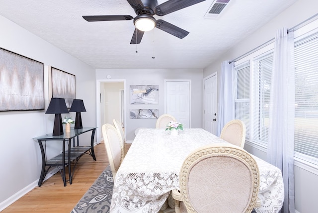 dining area with ceiling fan, a textured ceiling, and light wood-type flooring