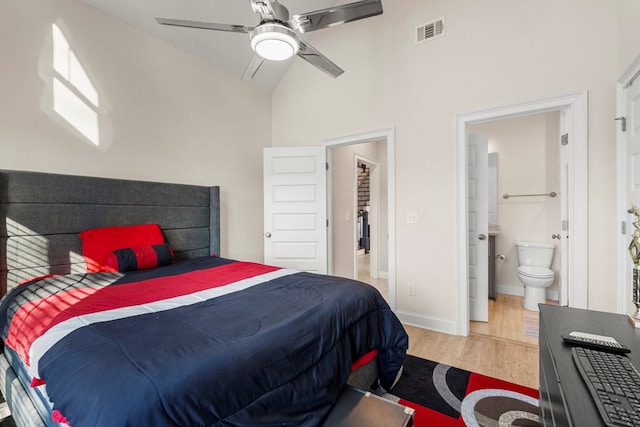 bedroom featuring wood-type flooring, connected bathroom, high vaulted ceiling, and ceiling fan