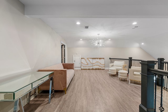 living area featuring a chandelier, hardwood / wood-style flooring, and vaulted ceiling