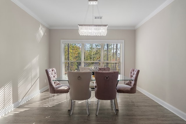 dining space featuring dark hardwood / wood-style floors, crown molding, and a notable chandelier