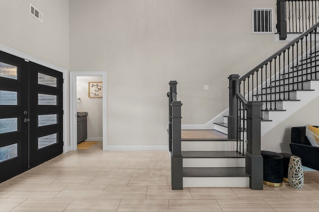 entryway with plenty of natural light, french doors, and a high ceiling