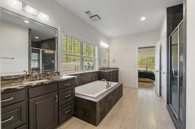 bathroom with tile patterned floors, vanity, and shower with separate bathtub