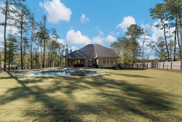 view of pool with a lawn and a hot tub