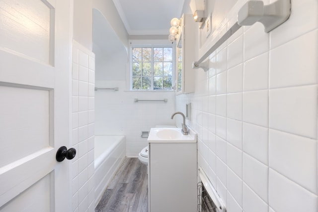 bathroom with hardwood / wood-style floors, tile walls, vanity, toilet, and crown molding