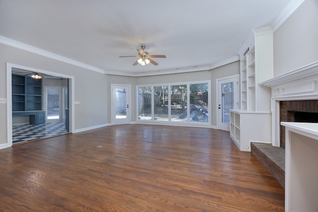 unfurnished living room with a brick fireplace, dark wood-type flooring, ornamental molding, and ceiling fan