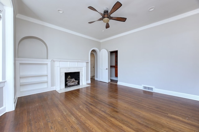 unfurnished living room featuring crown molding, dark hardwood / wood-style floors, ceiling fan, and a fireplace