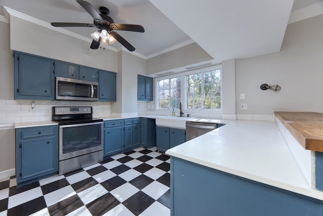 kitchen featuring crown molding, appliances with stainless steel finishes, blue cabinets, and sink