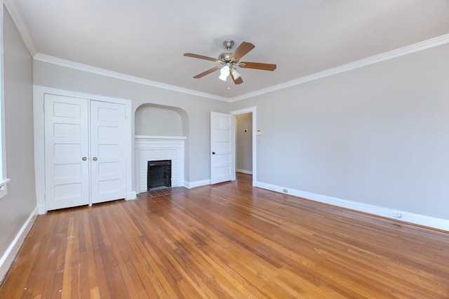 unfurnished living room with crown molding, dark wood-type flooring, a fireplace, and ceiling fan