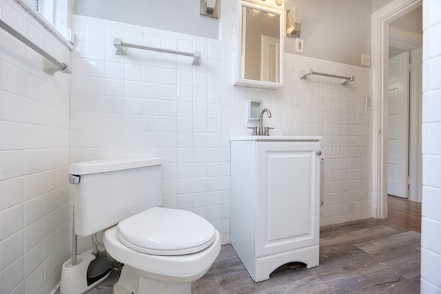 bathroom with tile walls, vanity, hardwood / wood-style flooring, and toilet