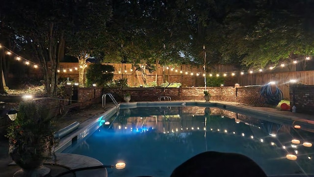 view of pool at twilight