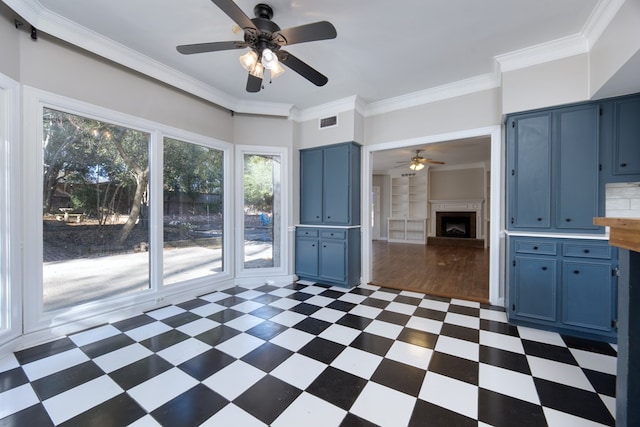 kitchen featuring blue cabinets, crown molding, and ceiling fan