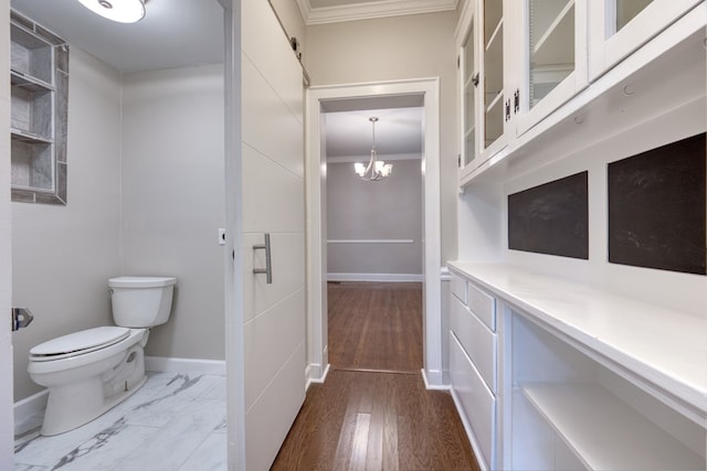 bathroom featuring hardwood / wood-style flooring, crown molding, a notable chandelier, and toilet