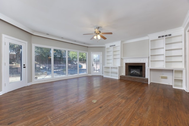 unfurnished living room with crown molding, ceiling fan, dark hardwood / wood-style flooring, and a brick fireplace