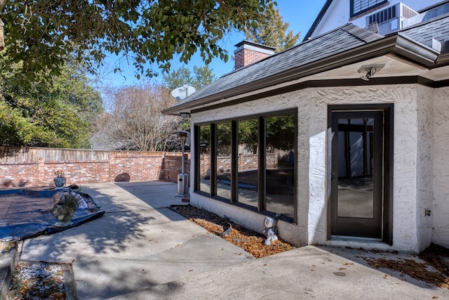 view of exterior entry with a patio area