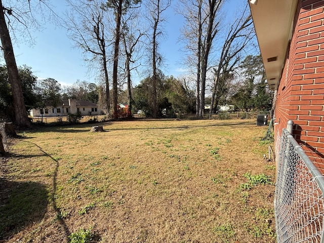 view of yard featuring central air condition unit and fence