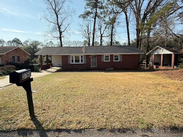 ranch-style home featuring a front lawn, an attached carport, and brick siding