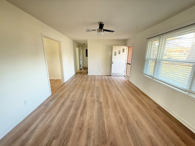 spare room with light wood-style floors, ceiling fan, and baseboards