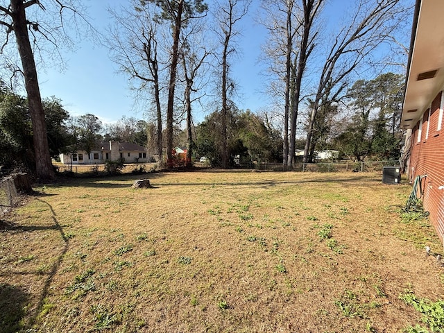 view of yard featuring fence and central air condition unit