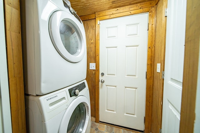 laundry room featuring wood ceiling, stacked washer / dryer, and wooden walls