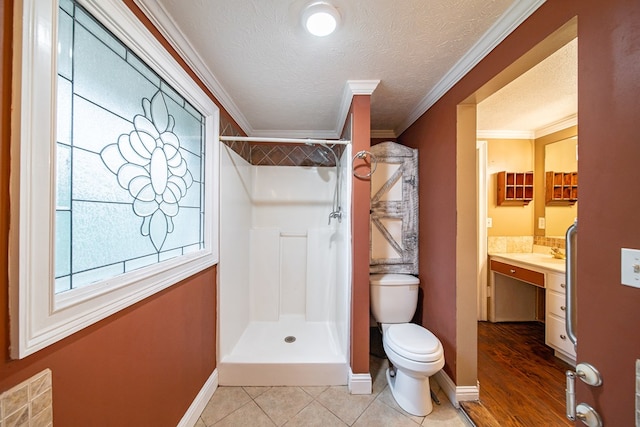 bathroom featuring a shower, a textured ceiling, and ornamental molding