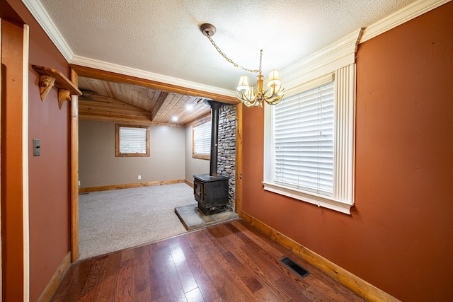 unfurnished living room featuring lofted ceiling, a wood stove, ornamental molding, a textured ceiling, and wood-type flooring