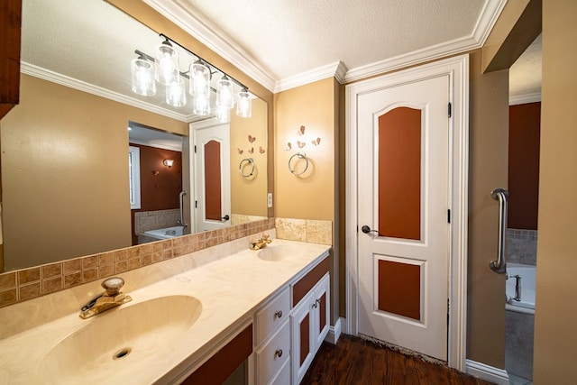 bathroom with hardwood / wood-style floors, vanity, a bath, crown molding, and a textured ceiling